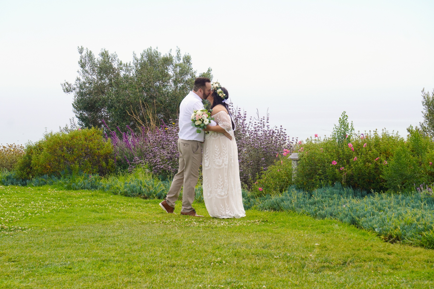 Ventura coastal wedding ceremony — couple kissing in a seaside garden in Ventura, California