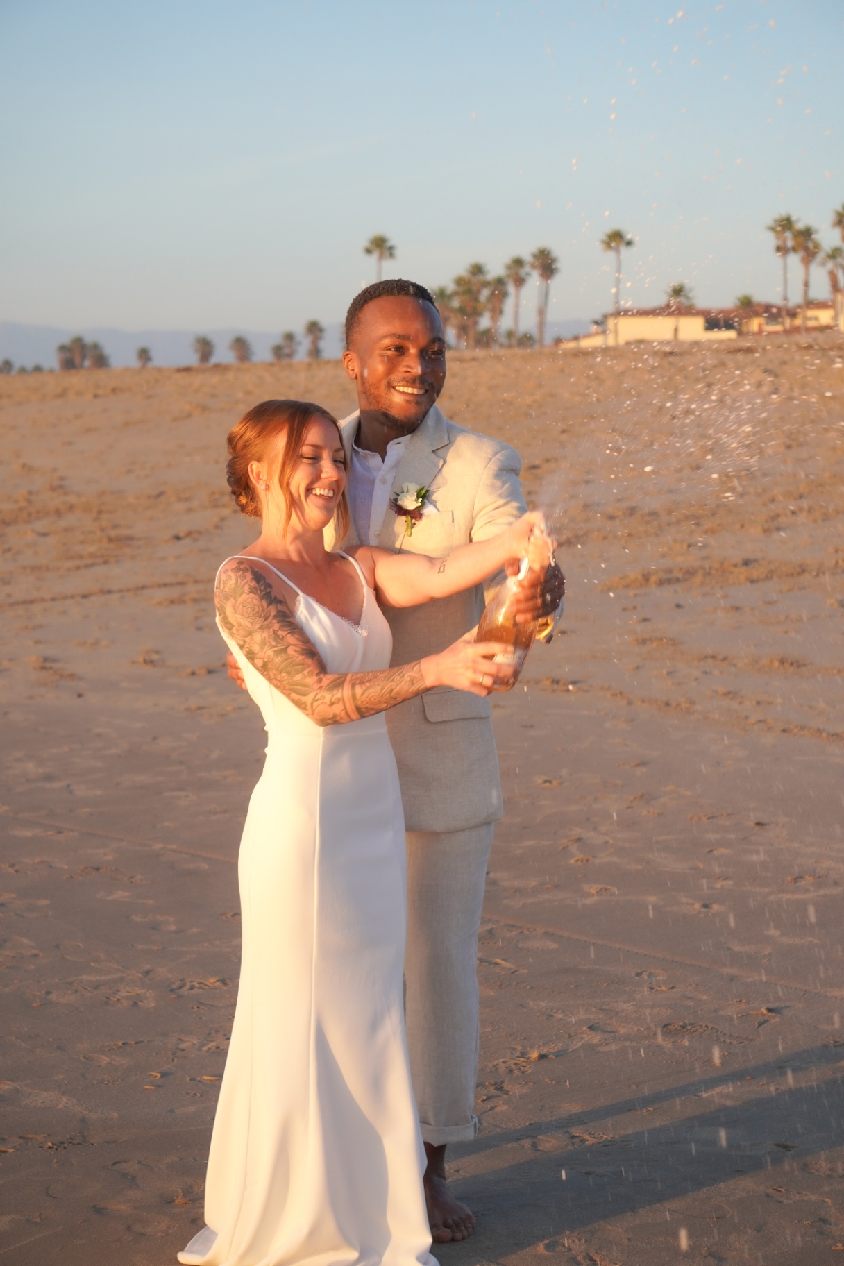 Oxnard beach wedding celebration with champagne spray at golden hour on the California coast