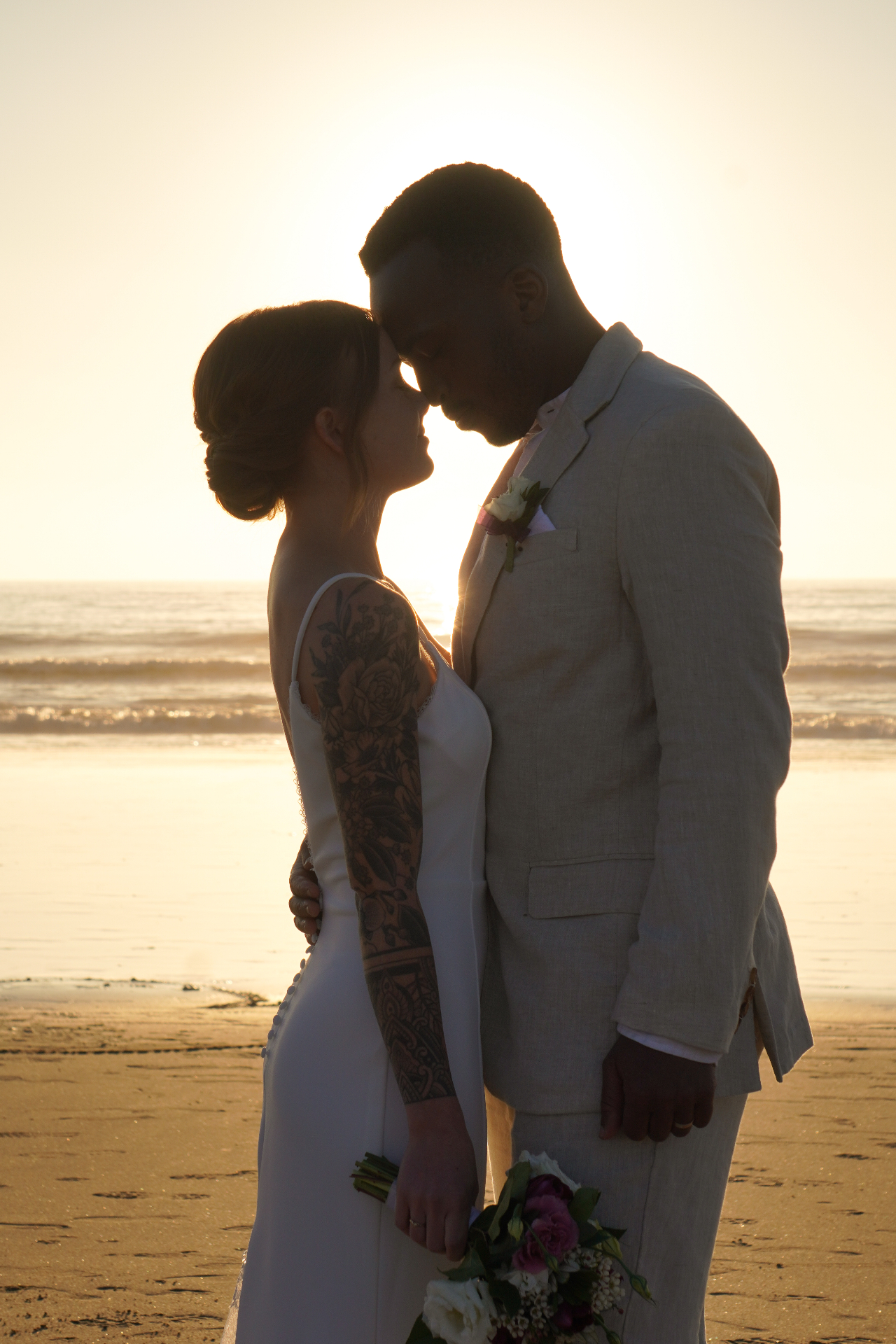 Sunset silhouette portrait of a couple during an Oxnard beach wedding on the Pacific coast