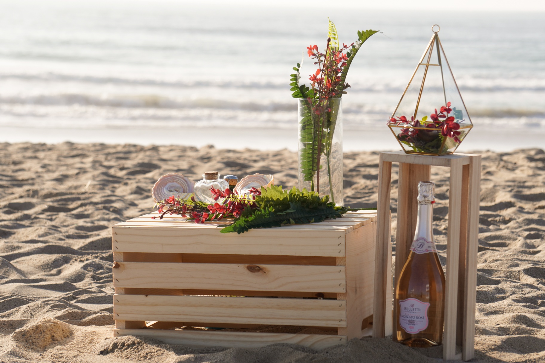 Oxnard beach elopement detail setup with florals, champagne, and ocean backdrop