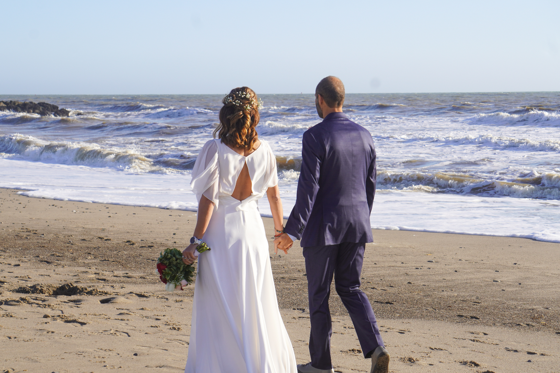 Ventura beach wedding couple walking hand in hand at San Buenaventura State Beach