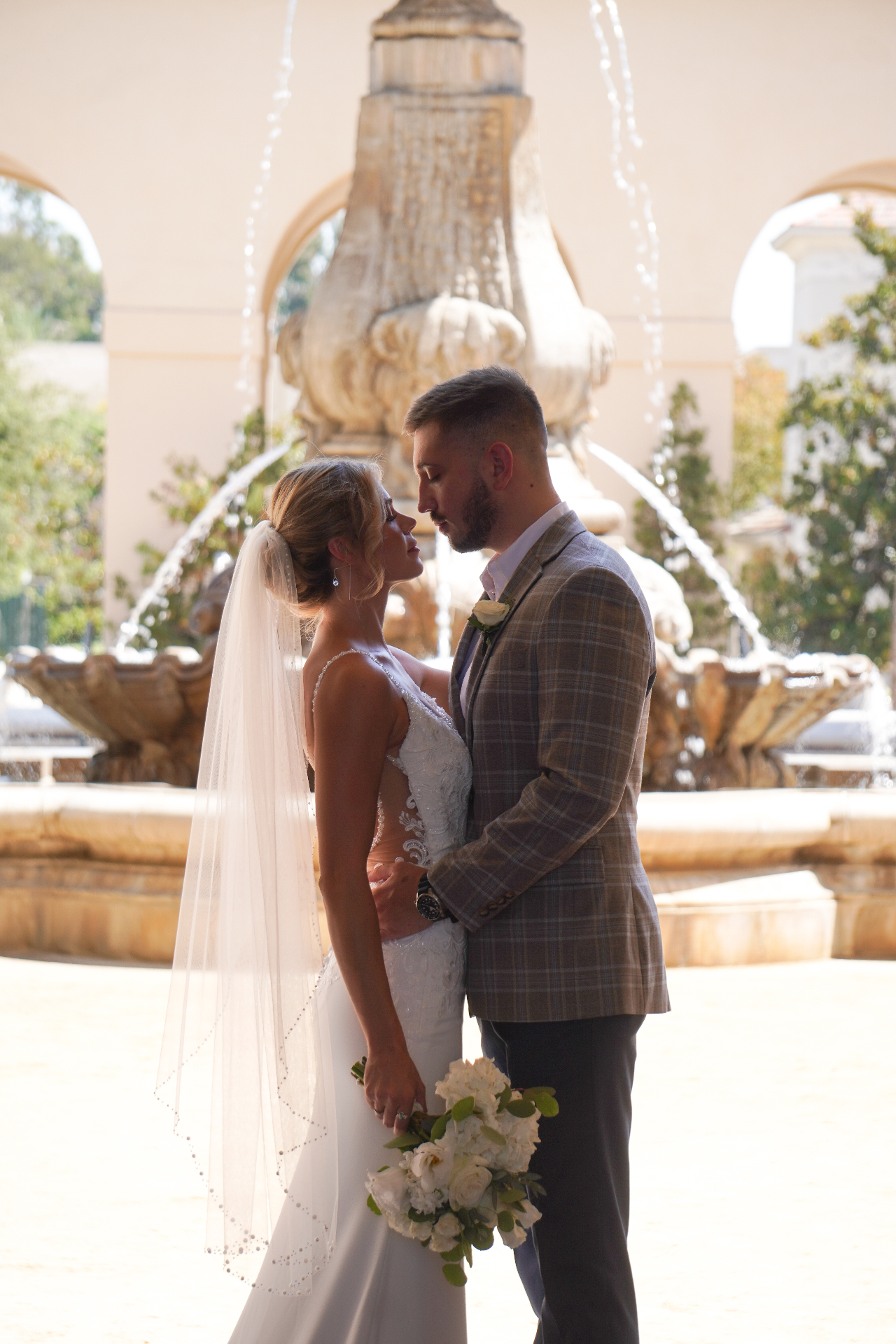 Santa Monica wedding couple embracing in front of a historic Pasadena fountain in golden afternoon light