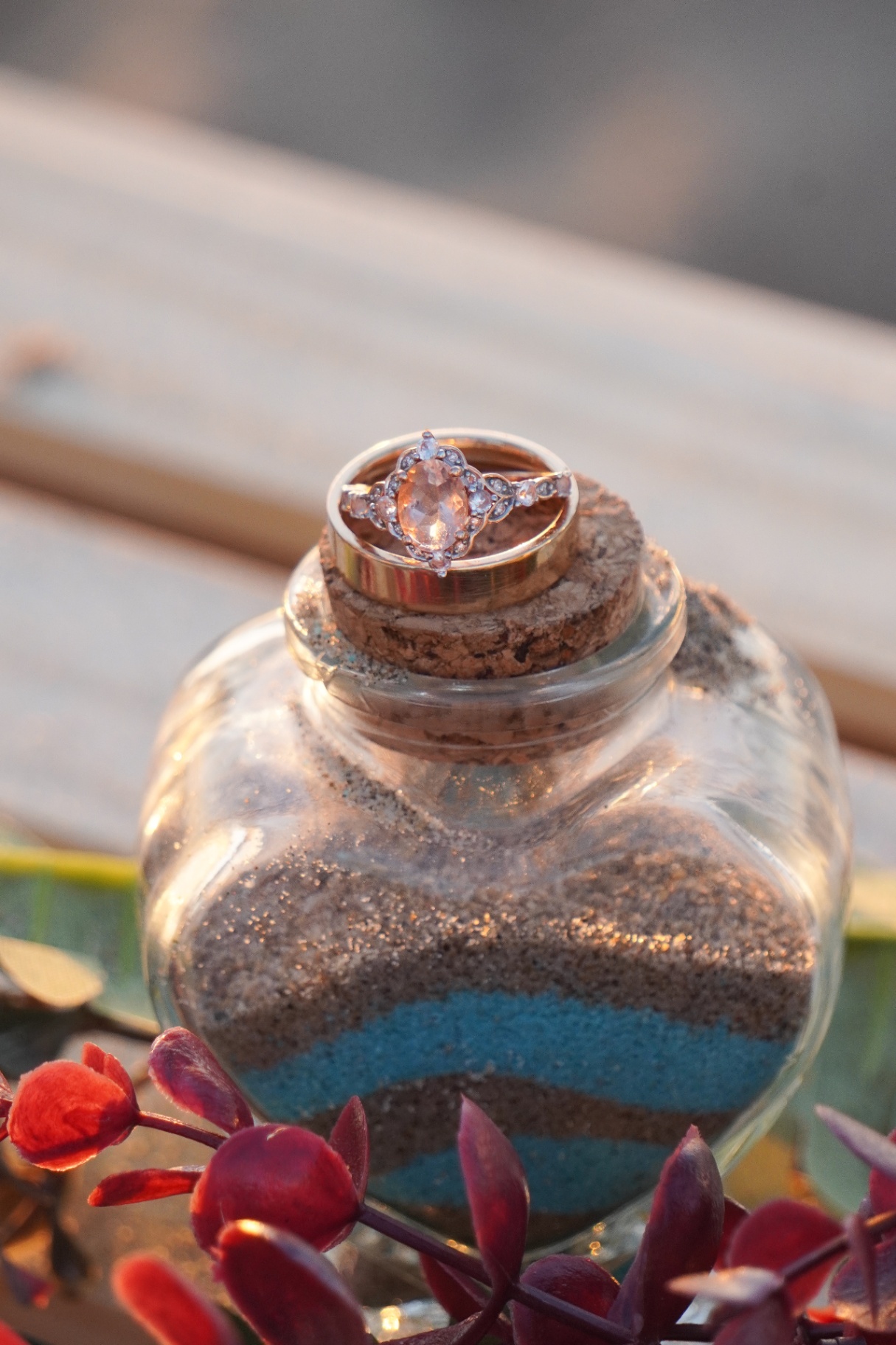 Wedding rings displayed in a sand ceremony vessel during an Oxnard beach elopement