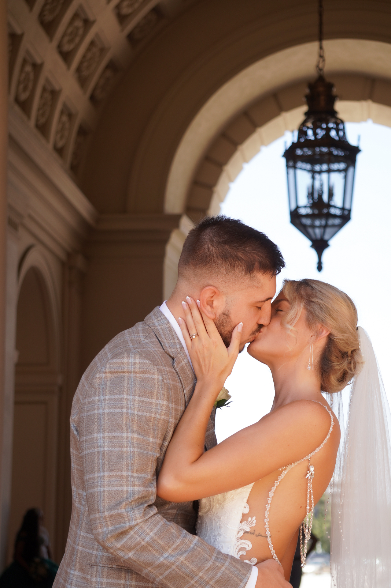 Los Angeles wedding couple sharing a first kiss under a grand archway at Pasadena City Hall