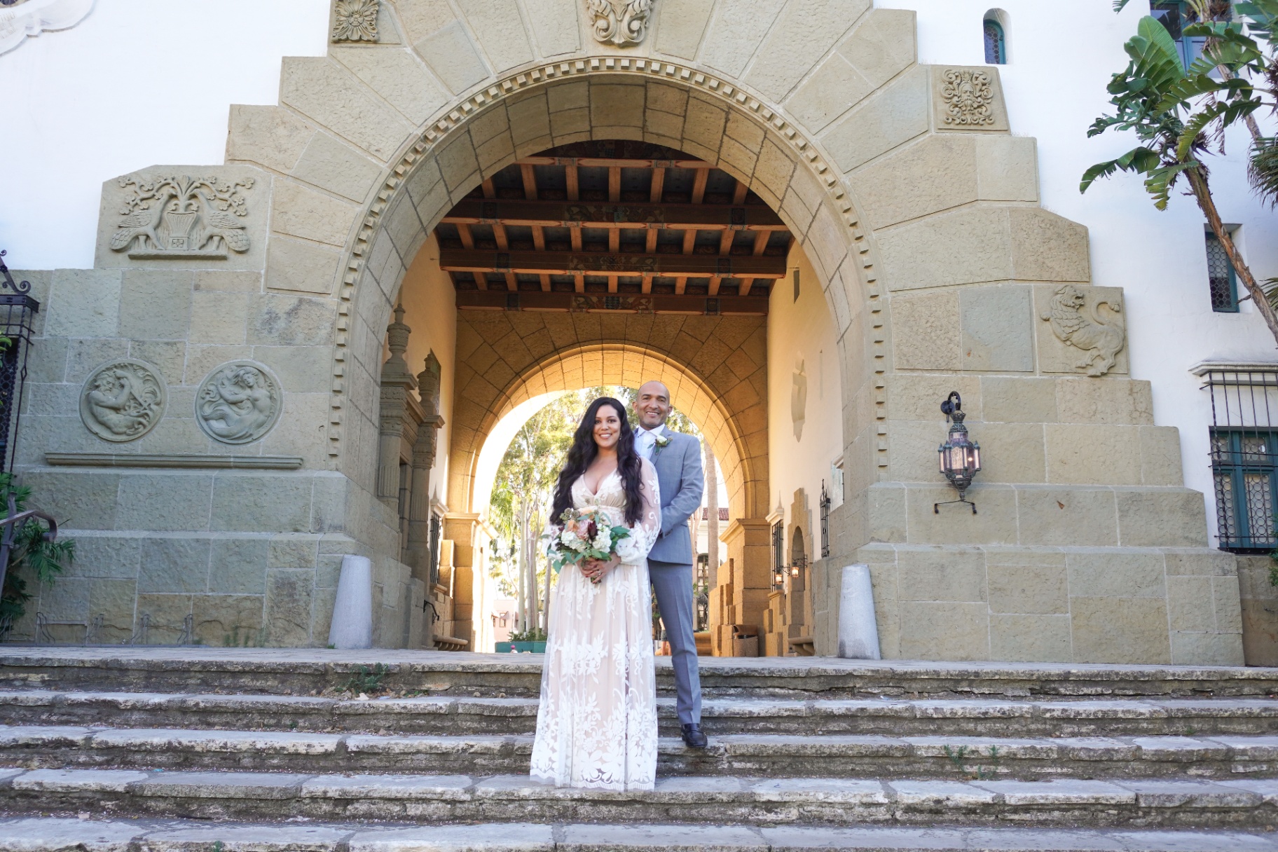 Bride and groom framed by the sandstone arch at the Santa Barbara Courthouse for a Spanish Colonial elopement